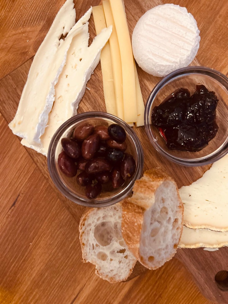 A rustic cheese and charcuterie board on a wooden table