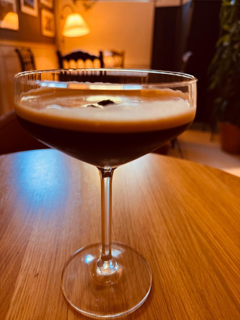 An espresso martini glowing in low, atmospheric light
