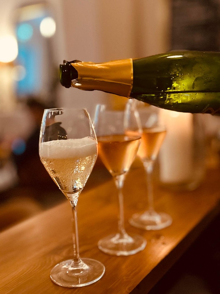 Champagne being poured into a glass in warm candlelight